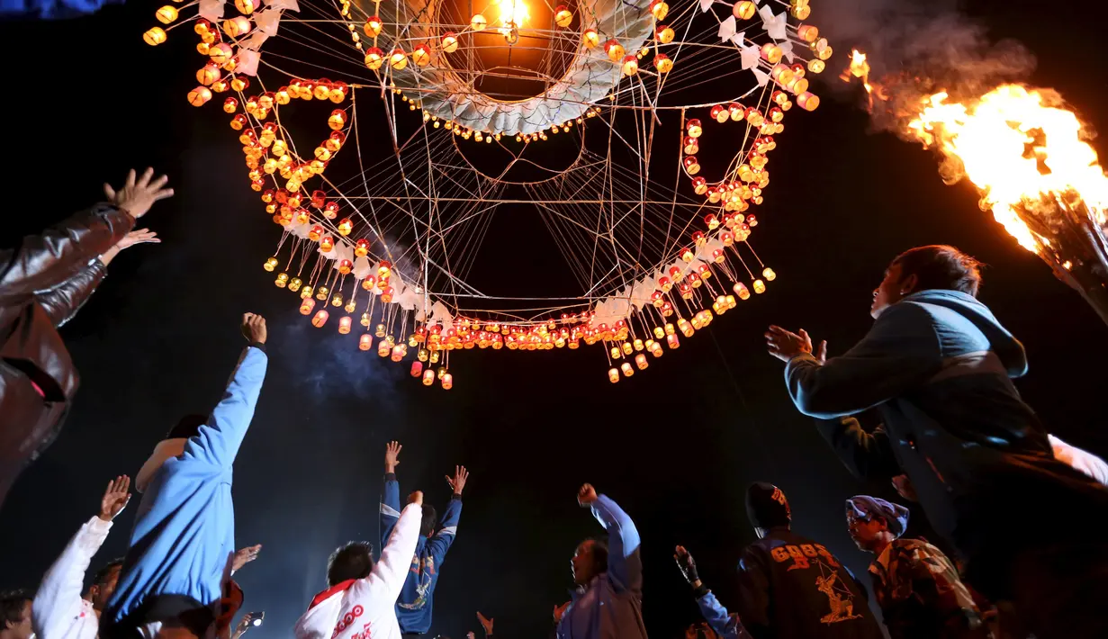 Sejumlah warga saat menerbangkan lampion buatan tradisional ke langit selama festival tahunan Tazaungdaing di Taunggyi, Myanmar (19/11). (REUTERS/Soe Zeya Tun)