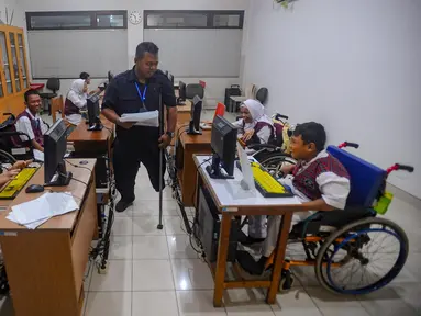 Pagi menjelang siang, suasana senyap menyelimuti ruangan kelas komputer. Pak Agung (39 tahun) berjalan hilir mudik mengawasi murid-murid penyandang disabilitas yang sedang mengerjakan tugas desain visual dengan menggunakan aplikasi canva. (merdeka.com/Arie Basuki)
