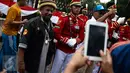 Warga berfoto bersama anggota Paspampres yang melakukan prosesi pergantian jaga Istana Kepresiden di depan Istana Merdeka, Minggu (28/8). Prosesi pergantian yang diwarnai sejumlah atraksi itu mengundang perhatian warga. (Liputan6.com/Faizal Fanani)