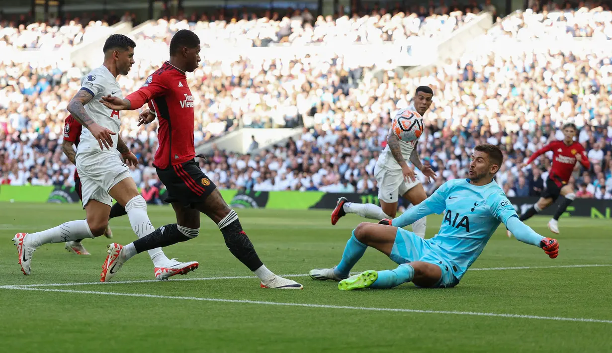 Kiper Tottenham Hotspur, Guglielmo Vicario (kanan) menghalau bola tendangan pemain Manchester United, Marcus Rashford (tengah) pada laga pekan kedua Liga Inggris 2023/2024 di Tottenham Hotspur Stadium, London, Inggris, Minggu (20/08/2023) WIB. (AFP/Adrian Dennis)
