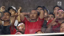 Ekspresi kekecewaan suporter saat menyaksikan laga Timnas Indonesia U-19 melawan Jepang U-19 pada perempat final Piala AFC U-19 2018 di Stadion GBK, Jakarta, Minggu (28/10). Indonesia kalah 0-2. (Liputan6.com/Helmi Fithriansyah)