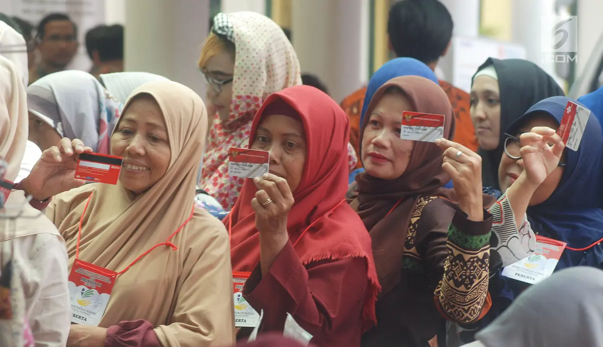 Warga menunjukkan KKS saat Penyaluran Bantuan Sosial PKH dan BPNT di Depok, Jawa Barat, Selasa (12/2). Jumlah bantuan PKH dan BPNT mencapai Rp.70.558.785.000 yang terdiri Rp44.098.560.000 untuk 33.408 Penerima BPNT. (Liputan6.com/Herman Zakharia)