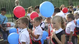 Anak-anak kelas satu mengikuti upacara yang menandai dimulainya kelas di sebuah sekolah di Mariupol, daerah yang dikuasai oleh pasukan separatis yang didukung Rusia, Ukraina timur, Kamis (1/9/2022). Banyak sekolah Ukraina dibuka kembali pada 1 September untuk pertama kalinya sejak invasi Rusia dimulai pada 24 Februari lalu. (AP Photo)