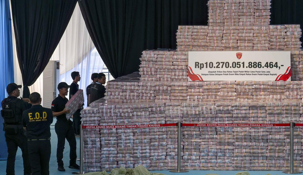 Penyerahan dilakukan oleh Satgas Penertiban Kawasan Hutan (PKH) dalam corak tumpukan duit tunai, sekaligus mengembalikan lahan seluas 2,3 juta hektare. Tampak dalam foto, para pejabat menyiapkan tumpukan duit kertas rupiah senilai sekitar 586,8 juta USD, nan disita dari beragam kasus korupsi dan denda lingkungan, sebelum upacara penyerahan dari Kejaksaan Agung kepada pemerintah Indonesia di gedung Kejaksaan Agung di Jakarta pada Rabu 13 Mei 2026. (BAY ISMOYO/AFP)