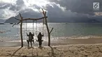 Dua wanita bermain ayunan saat menikmati Pantai Mutiara di Trenggalek, Jawa Timur, Sabtu (7/9/2019). Pantai Mutiara salah satu tujuan wisata yang sedang dikembangkan kabupaten Trenggalek. (Liputan6.com/Herman Zakharia)