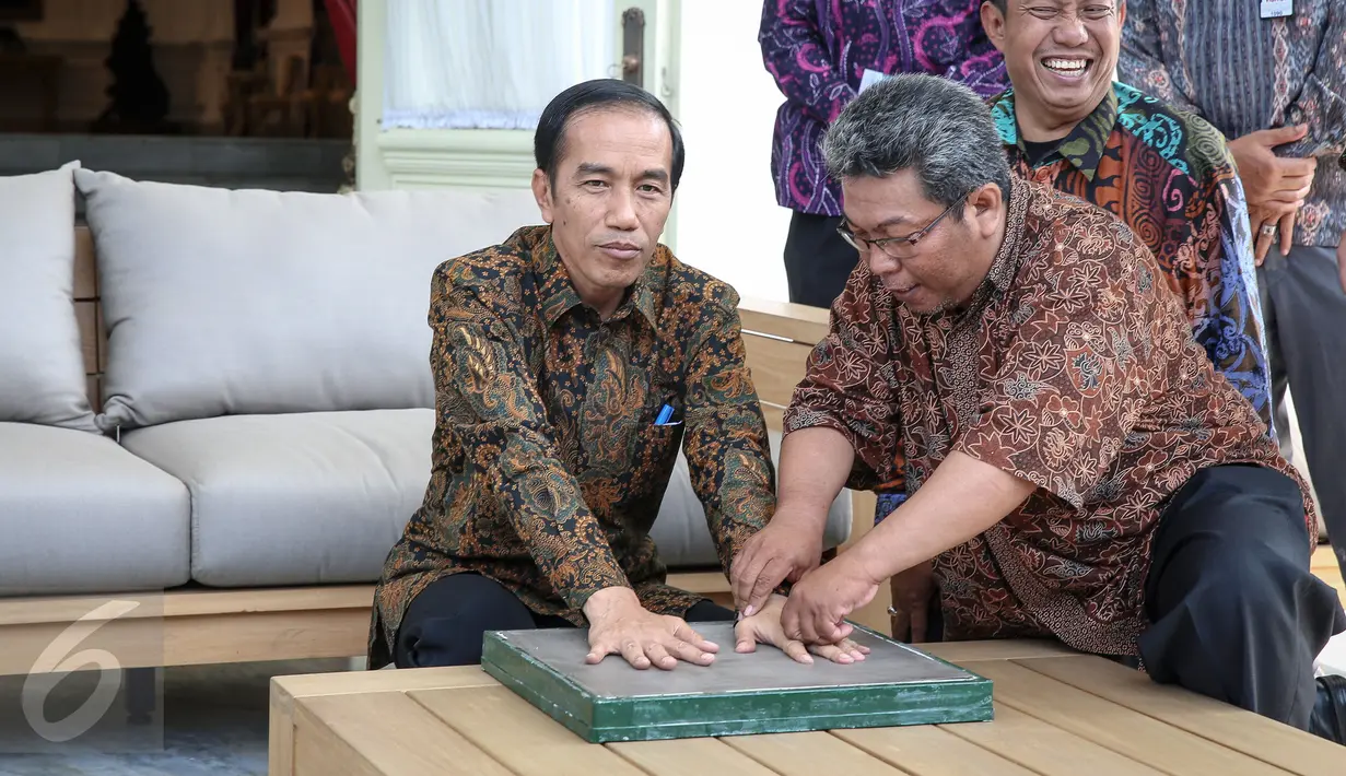 Presiden Joko Widodo saat meletakkan tangannya kearah tempat pencetakan di Istana Merdeka, Jakarta, Selasa (13/10/2015). Cetakan tersebut akan diletakkan di Taman Pintar Yogyakarta. (Liputan6.com/Faizal Fanani)