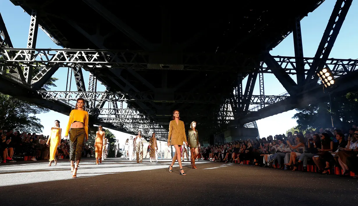 Sejumlah model berpose saat memperagakan busana Manning Cartell di bawah jembatan Sydney Harbour Bridge dalam acara Australian Fashion week, 17 Mei 2016. (REUTERS/Jason Reed)