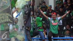 Pendukung Persebaya 1927 atau Bonek bernyayi dan membakar suar saat aksi di Stadion Tugu, Jakarta, Rabu (3/8). Bonek menyerbu Jakarta sejak Selasa (2/8) untuk mendesak pengakuan klub Persebaya 1927 pada KLB PSSI. (Liputan6.com/Helmi Fithriansyah)