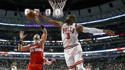 Pemain Chicago Bulls, Dwyane Wade (kanan) menepis bola tembakan pemain Washington Wizards, Marcin Gortat pada laga NBA basketball game di United Center, Chicago, (21/12/2016).  Wizards menang 107-97. (AP/Charles Rex Arbogast)