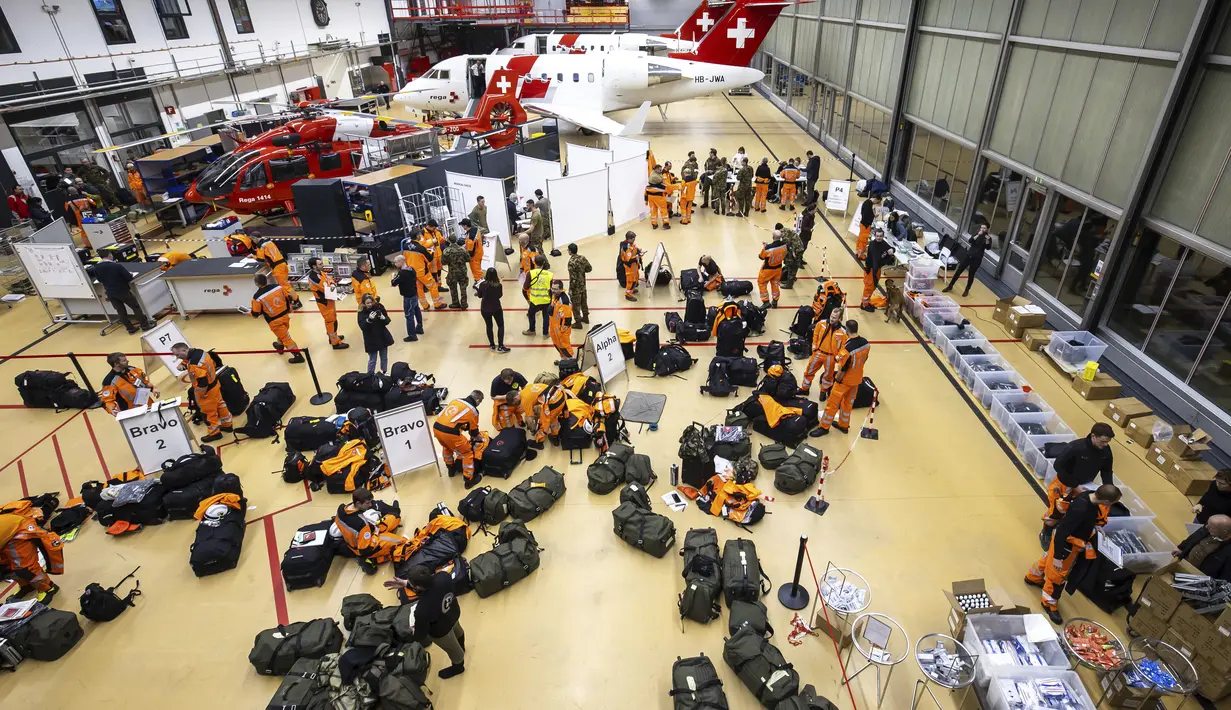 Pakar dan penyelamat Swiss dengan anjing pemandu bersiap untuk terbang ke Turki yang dilanda gempa, di Bandara Zurich, Swiss, Senin (6/2/2023). Gempa kuat telah merobohkan beberapa bangunan di tenggara Turki dan Suriah dan dikhawatirkan banyak korban jiwa. (Michael Buholzer/Keystone via AP)
