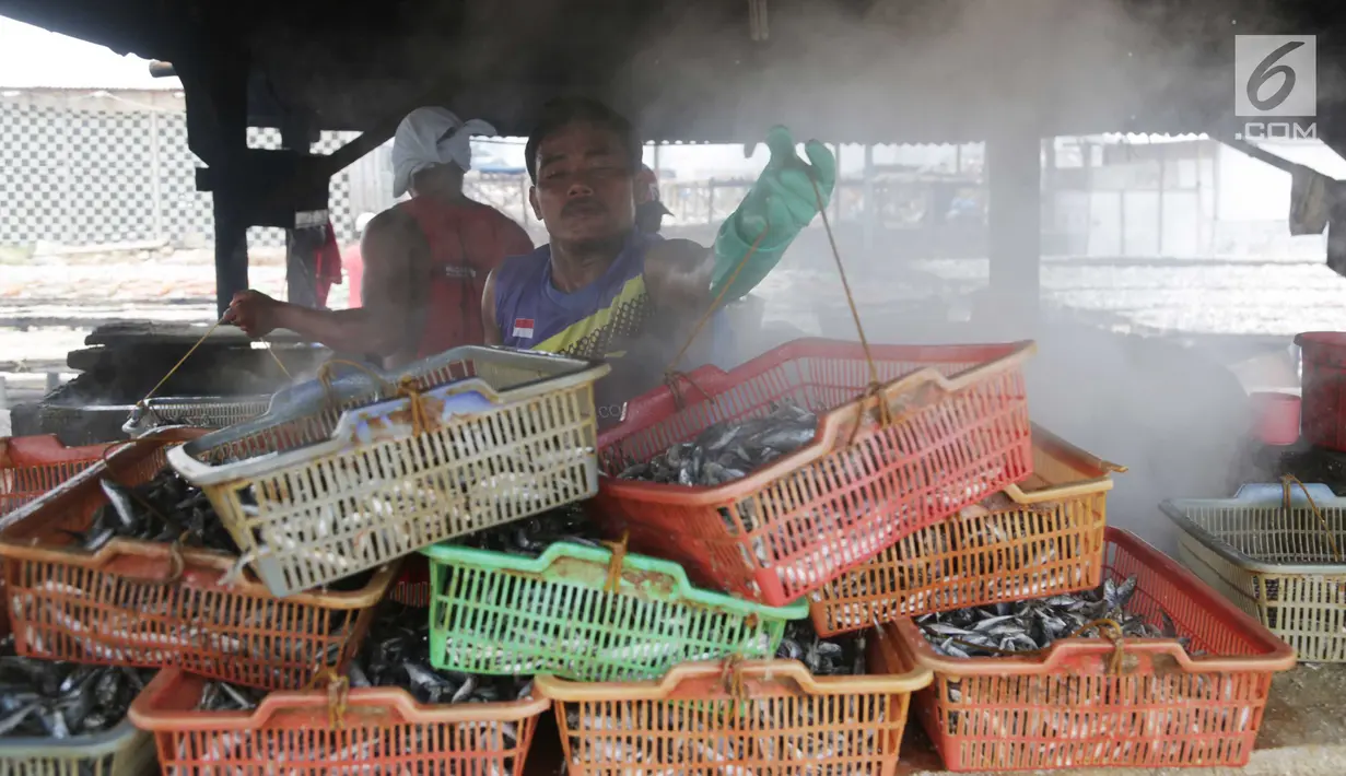 Warga memasak ikan asin secara tradisional di Muara Angke, Jakarta, Rabu (13/9). Produksi ikan asin yang merupakan usaha rumah tangga nelayan di daerah tersebut mengalami peningkatan hingga 50 persen saat musim kemarau. (Liputan6.com/Angga Yuniar)