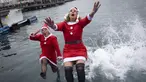 Sejumlah peserta berkostum Sinterklas melompat ke dalam air dalam ajang Copa Nadal yang berlangsung di Barcelona's Port Vell, Barcelona, Kamis (25/12/2025) waktu setempat. Acara tersebut diikuti lebih dari 450 peserta. (AFP/Josep Lago)