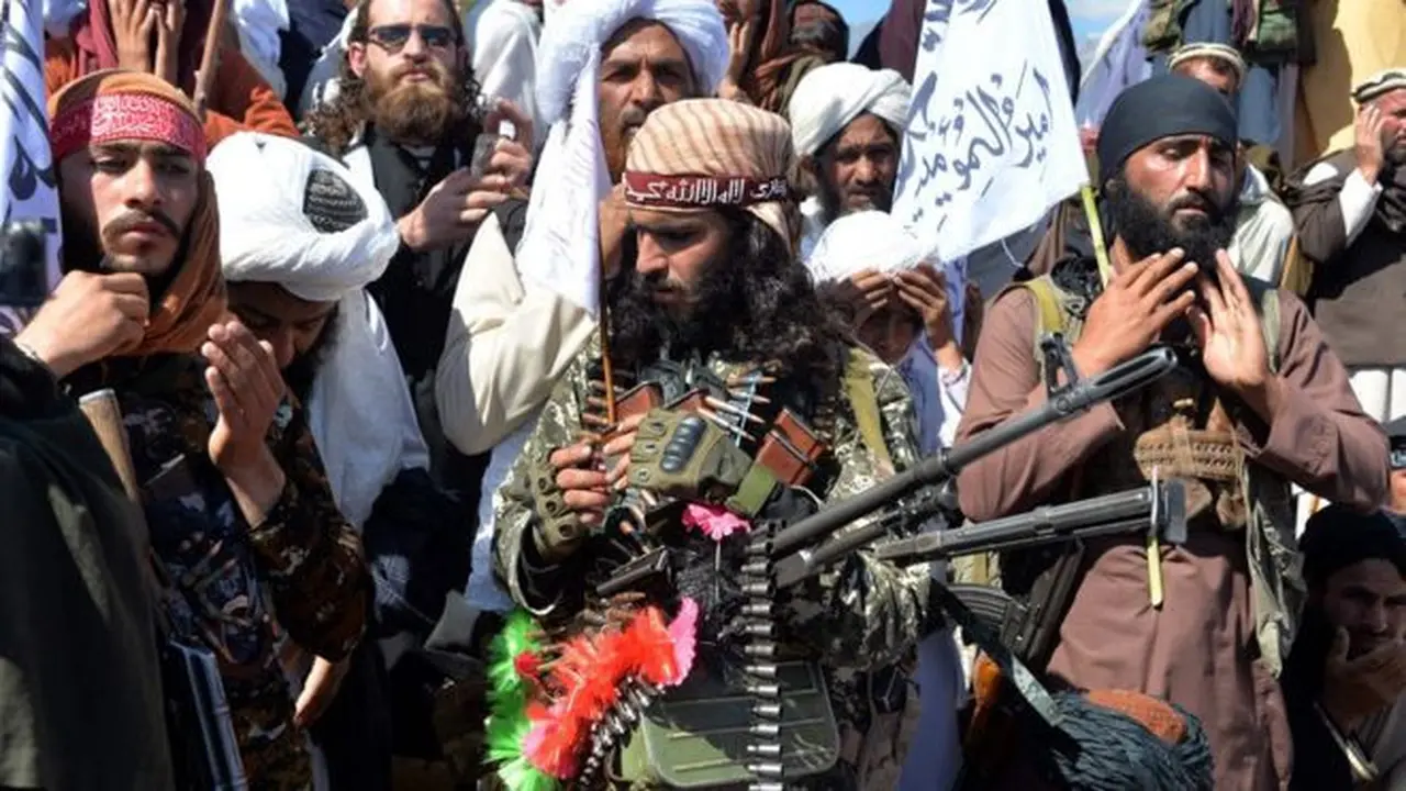 Militan Taliban dan warga desa digambarkan sedang merayakan perjanjian damai pada hari Senin.