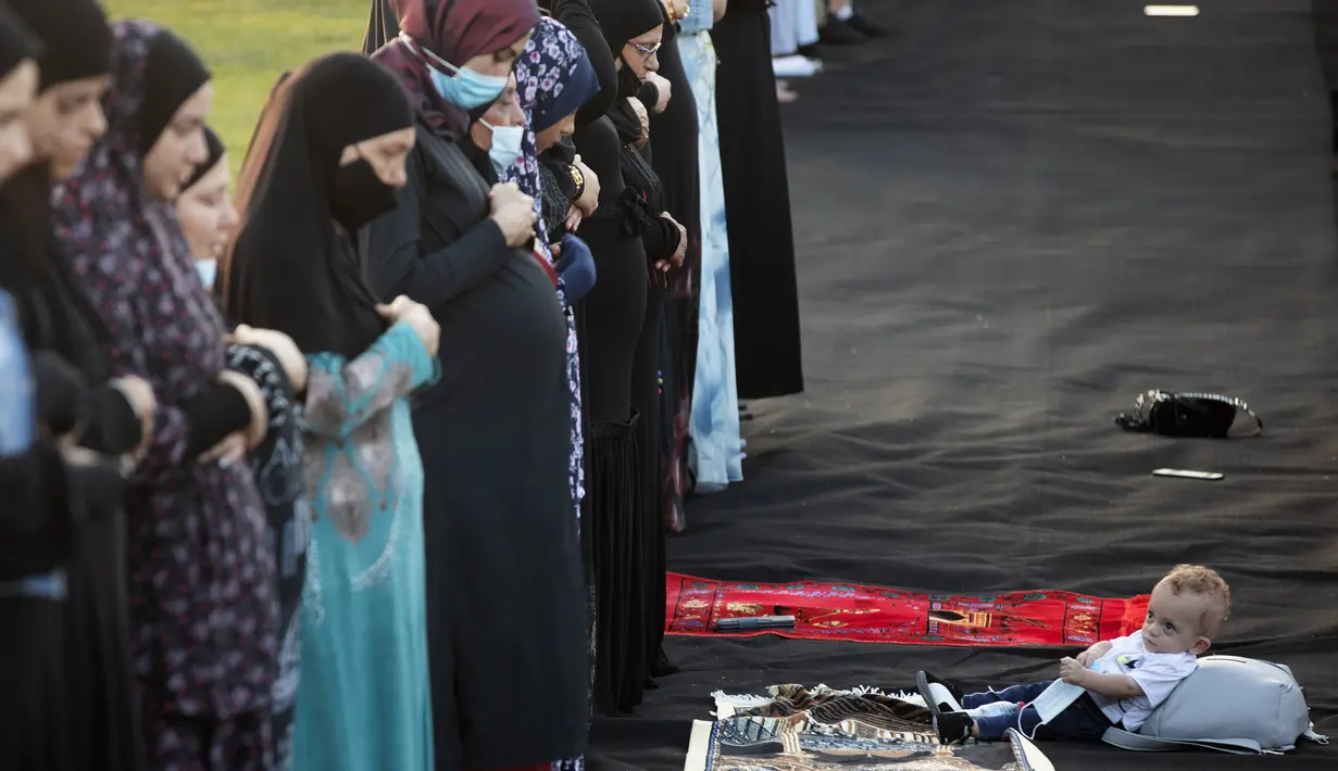 Umat muslim melaksanakan salat Idul Adha di sebuah taman kota campuran Yahudi dan Arab, Jaffa, Israel, Jumat (31/7/2020). Ini adalah Idul Adha pertama sejak awal pandemi COVID-19. (AP Photo/Oded Balilty)