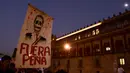Pengunjuk rasa mengangkat poster tengkorak Presiden Enrique Pena Nieto saat demonstrasi menolak kenaikan harga BBM, Mexico City, Meksiko (9/1). Akibat kenaikan BBM, sebagian warga nekat melakukan aksi vandalisme hingga penjarahan. (AFP/Alfredo Estrella)