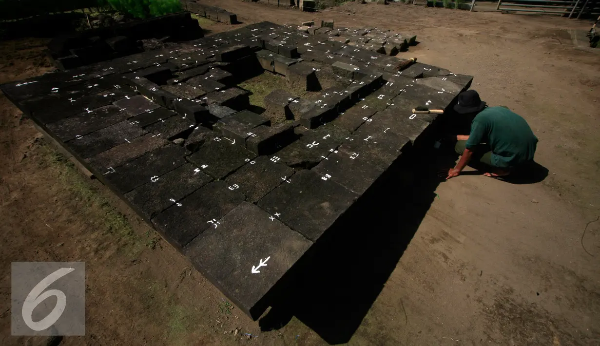 Seorang pekerja memberikan tanda pada batu andesit candi Palgading, Ngaglik, Sleman, Kamis (12/5/16). Candi peninggalan zaman kerajaan mataram Kuno ini akan di pugar hingga 10 Oktober 2016. (Liputan6.com/Boy Harjanto)