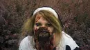 Seorang peserta wanita memamerkan hasil karyanya berupa wajah Zombie yang menyeramkan saat Parade Zombie di Praha, Ceko, Sabtu (24/05/2014) (AFP PHOTO/Michal Cizek)