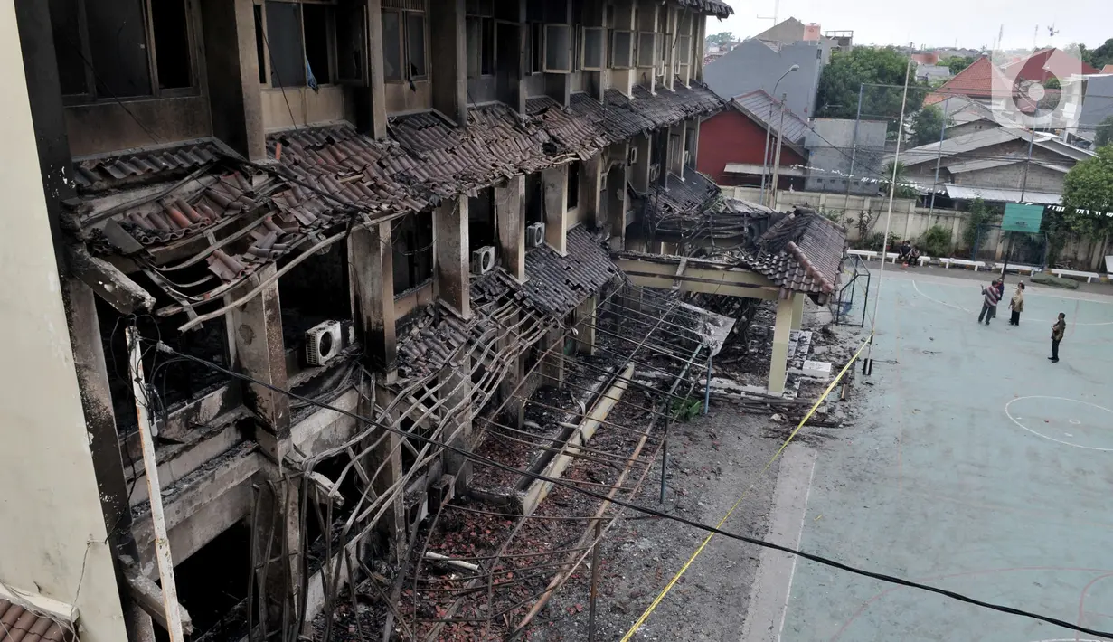 Sejumlah guru melihat kondisi gedung SMK Yadika 6 pascakebakaran, Jatiwaringin, Pondok Gede, Kota Bekasi, Jawa Barat, Selasa (19/11/2019). Kebakaran yang bermula di ruang lab komputer akibat korsleting listrik tersebut sedikitnya menyebabkan 14 orang terluka. (merdeka.com/Iqbal Nugroho)