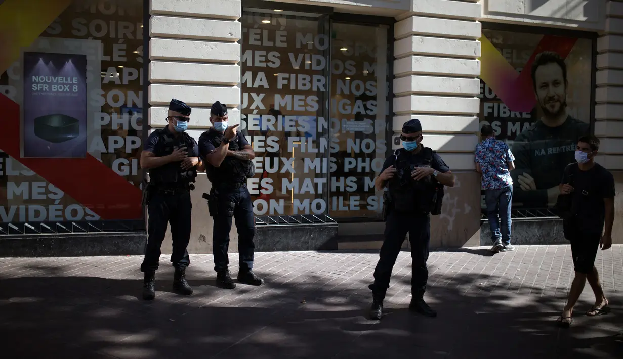 Polisi anti huru-hara Prancis mengamati warga yang mengenakan masker di Marseille, Selasa (18/8/2020). Pemerintah Prancis mengirim polisi anti huru hara ke wilayah Marseille untuk membantu menegakkan peraturan penggunaan masker saat negara itu mencatat lonjakan kasus COVID-19. (AP Photo/Daniel Cole)