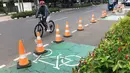 Pesepeda lewat di dekat jalur khusus sepeda, Blok M, Jakarta, Selasa (24/11/2020). Gubernur Anies Baswedan memperkirakan pembangunan jalur sepeda sepanjang 500 km di Ibu Kota bakal tertunda karena anggaran masih difokuskan untuk penanggulangan Covid-19 dan banjir. (Liputan6.com/Immanuel Antonius)