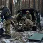 Petugas medis militer memberikan pertolongan pertama kepada tentara yang terluka (kanan) dan memasukkan jenazah tentara yang tewas ke dalam tas dekat Kremenna di wilayah Luhansk, Ukraina, 16 Januari 2023. Hingga saat ini pejabat Ukraina menolak untuk mengonfirmasi jumlah korban dalam perangnya dengan Rusia, setelah ketua Komisi Uni Eropa pada akhir November 2022 lalu memperkirakan bahwa "lebih dari 20.000 warga sipil dan 100.000 tentara Ukraina telah tewas di Ukraina hingga saat ini." (AP Photo/LIBKOS)