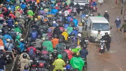 Kondisi ini disebabkan oleh curah hujan lebat yang disertai angin kencang sejak tengah malam tadi hingga meluapnya aliran Kali Mookervart. Tampak dalam foto, antrean pengendara motor yang mencoba menerobos banjir di Jalan Daan Mogot, Jakarta, Jumat (23/1/02026). (merdeka.com/ Arie Basuki)