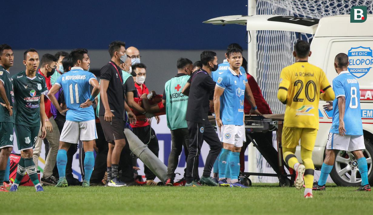 Sejumlah tenaga medis mengevakuasi kiper Sulut United, Fery Bagus Kurniawan menuju ambulans usai insiden tabrakan dengan pemain PSMS Medan dalam matchday pertama Grup Y Babak 8 Besar Liga 2 2021 di Stadion Wibawa Mukti, Cikarang, Kamis (16/12/2021). (Bola.com/Bagaskara Lazuardi)