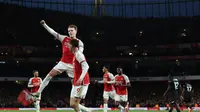 Gelandang Arsenal, Martin Odegaard (melompat), merayakan gol yang dicetaknya ke gawang Luton Town bersama rekan setimnya yang memberikan assist, Kai Havertz, dalam laga pekan ke-21 Premier League 2023/2024 di Emirates Stadium, Kamis (4/4/2024) dini hari WIB. Arsenal menang 2-0 dalam laga ini. (Adrian DENNIS / AFP)