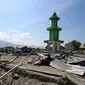 Warga membawa papan bertuliskan Kami Butuh Bantuan Pak Jokowi di atas reruntuhan puing pasca gempa bumi dan tsunami di Jalan Trans Sulawesi, Palu, Sulawesi Tengah, Kamis (4/10). (Liputan6.com/Fery Pradolo)