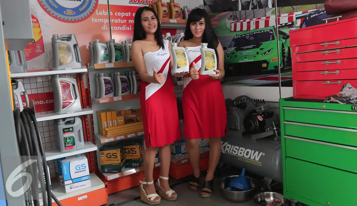 Dua SPG memperlihatkan oli saat meresmikan outlet Bright Olimart di SPBU Cakung, Jakarta, Senin (26/10). Outlet ini merupakan pelayanan servis pengendara bermotor. (Liputan6.com/Angga Yuniar)