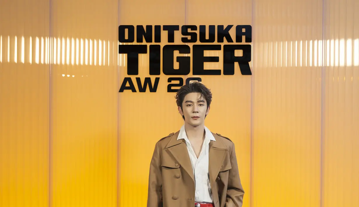 Aktor dan penyanyi Tiongkok Xia Zhi Guang tampil maskulin dengan trench coat cokelat klasik yang dipadukan dengan kemeja putih terbuka di bagian kerah. Ia mengenakan celana hitam dan sepatu loafers yang menghadirkan keseimbangan antara gaya formal dan kasual, mencerminkan karakter refined khas koleksi Onitsuka Tiger. [Dok/Onitsuk Tiger].