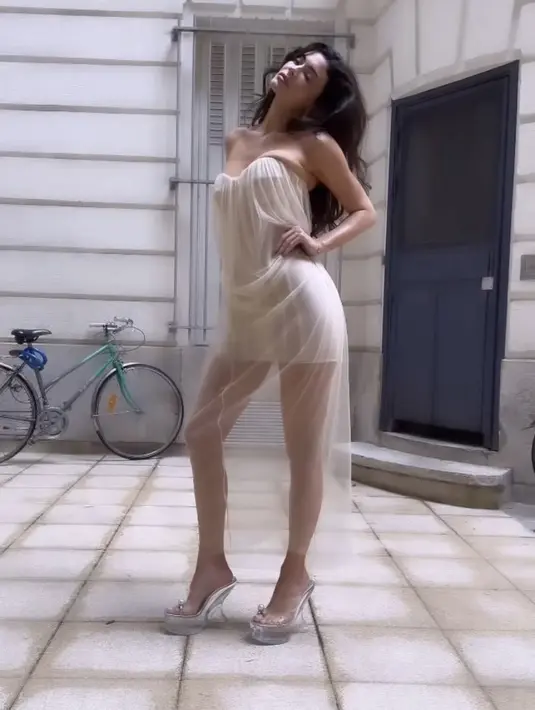 Dress tersebut dipadukan platform heels metalik. Dengan gaya rambut bergaya keriting terurai. [@kyliejenner]