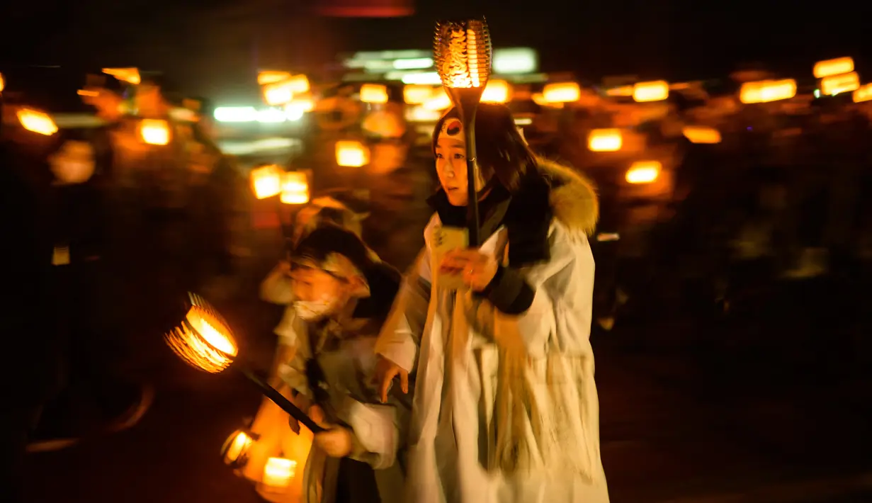 Peserta mengenakan kostum tradisional sambil memegang lentera LED, saat berbaris untuk merayakan peringatan Gerakan Kemerdekaan 1 Maret di Cheonan, 90 kilometer selatan Seoul pada 28 Februari 2023. Warga Korea Selatan merayakan hari libur peringatan untuk menandai pemberontakan sipil 1919 melawan Pemerintahan kolonial Jepang dari tahun 1910-1945. (AFP/Anthony Wallace)