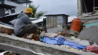 Seorang pria berduka atas jenazah korban gempa di Kota Mamuju, Sulawesi Barat, Indonesia, Jumat (15/1/2021). BMKG menyebut pusat gempa berada di darat, 6 kilometer timur laut Majene pada kedalaman 10 kilometer. (Firdaus/AFP)