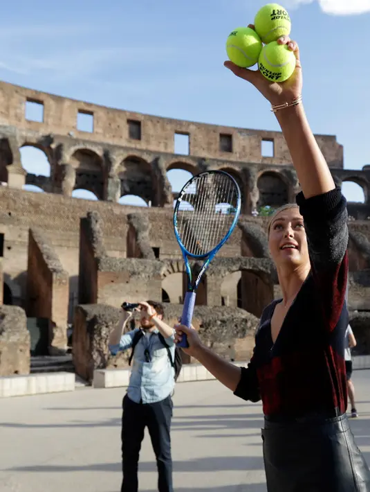 Petenis asal Rusia, Maria Sharapova bersiap memukul bola saat mengunjungi Colosseum, Roma, Italia (14/5). Sharapova sebelumnya terkena hukuman larangan bertanding akibat terjerat kasus doping. (AP Photo / Gregorio Borgia)