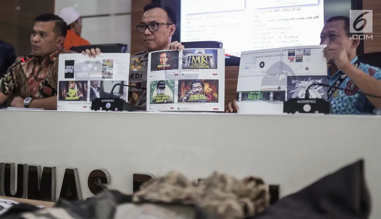 Karopenmas Divisi Humas Polri Brigjen Pol Dedi Prasetyo (tengah) menunjukkan barang bukti kasus propaganda dan penyebaran hoaks SARA di Mabes Polri, Jakarta, Jumat (28/6/2019). Polisi menyita barang bukti laptop, hp, hardisk, dan atribut laskar FPI. (Liputan6.com/Faizal Fanani)