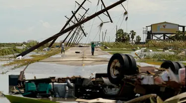 Orang-orang mengamati kerusakan yang ditinggalkan setelah Badai Laura mendarat di Holly Beach, Louisiana, AS, Kamis (27/8/2020). Laura merupakan badai tingkat empat yang masuk kategori monster. (AP Photo/Eric Gay)