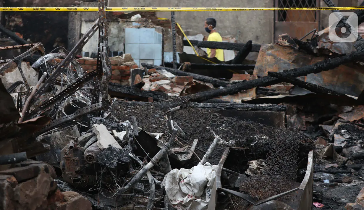 Warga melintasi pemukiman yang hangus terbakar di kawasan Duri Utara, Tambora, Jakarta, Rabu (12/8/2020). 382 kepala keluarga atau 974 jiwa kehilangan tempat tinggal akibat kebakaran di kawasan Duri Utara, Tambora, Jakarta Barat, pada Selasa (11/8/) malam. (Liputan6.com/Helmi Fithriansyah)
