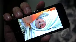 Vokalis Ada Band, Donnie Sibarani saat menunjukan foto bayi laki-lakinya yang lahir pada 18 April lalu di RS Bersalin Asih dan diberi nama Kent Leopold Sibarani, Jakarta, Selasa (21/4/2015). (Liputan6.com/Faisal R Syam)