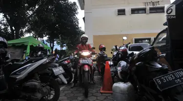 Pegawai kantor Balai Kota DKI Jakarta mengambil motor di Kelurahan Kebon Sirih, Jakarta, Rabu (16/1). Pelarangan pegawai Balai Kota untuk memarkirkan kendaraan di Gedung DPRD menyebabkan halaman Kelurahan penuh dengan motor. (Merdeka.com/Iqbal S Nugroho)