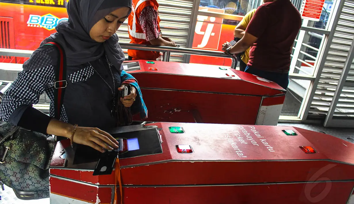 Calon penumpang TransJakarta melakukan tapping (menempelkan) e-ticketing di koridor I Harmoni, Jakarta, (23/10/14). (Liputan6.com/Faizal Fanani)