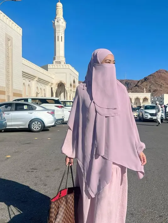 Pada potret lain memperlihatkan Titi kamal mengenakan gamis dan khimar warna lilac, yang dilengkapi cadar. [@titi_kamall]