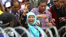 Pendukung Cagub DKI Basuki T Purnama memberikan salam dua jari saat sidang kasus penistaan agama, Jakarta, Selasa (10/1). Dengan mengenakan atribut kotak-kotak, massa membawa bendera Indonesia serta melakukan orasi damai. (Liputan6.com/Immanuel Antonius)
