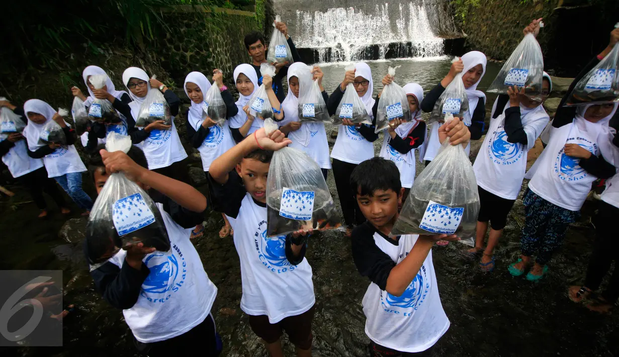 Siswa membawa benih ikan yang akan di lepas pada Baksos Jurnalis Joran Indonesia, Care To Share di SDIT Ibnu Abbas , Pakem ,Sleman, Yogyakarta, (2/4). Acara diakhiri pelepasan benih ikan di sungai Denggung yang berhulu dari puncak Merapi. (Boy Harjanto)
