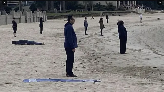 Foto Sekelompok Berpakaian Serba Hitam Menghadap Pantai