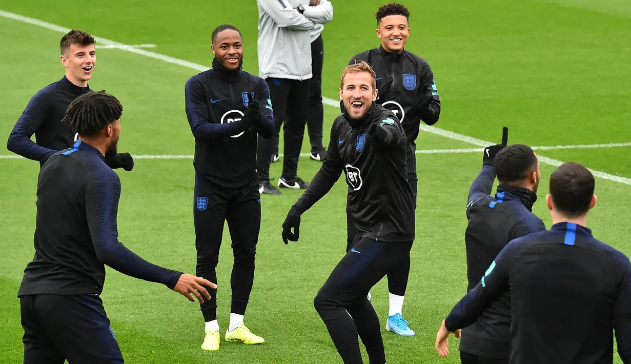 Striker Inggris Harry Kane (tengah) tertawa saat mengikuti sesi pelatihan tim  di Staplewood Campus di southampton, Inggris selatan (9/9/2019). Inggris akan bertanding melawan Kosovo pada grup A Kualifikasi Euro 2020 di Stadion Saint Mary. (AFP Photo/Glyn Kirk)