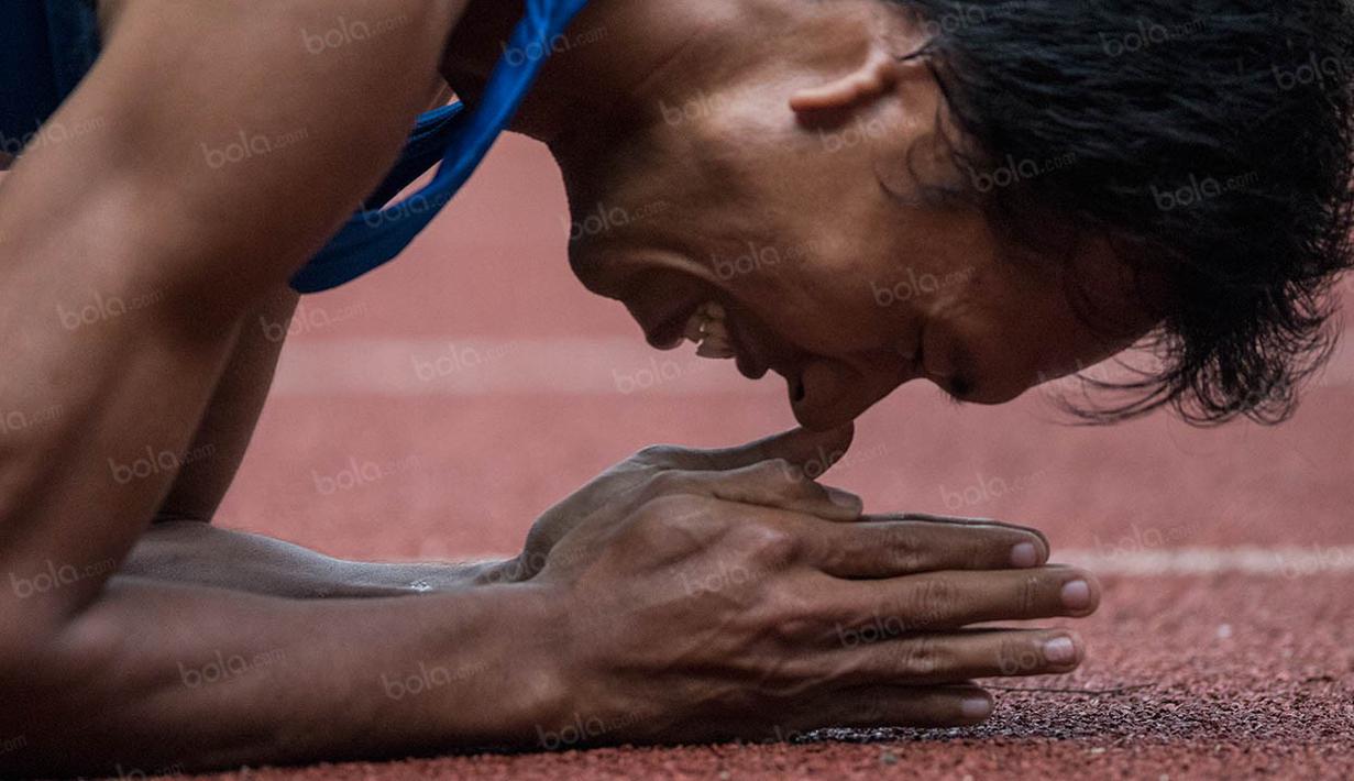 Atlet Jawa Tengah, Ega Rizki Firmanto, melakukan selebrasi usai memenangi nomor 200 meter T +54 putra pada Peparnas XV di Stadion Gelora Bandung Lautan Api, Bandung, Kamis (20/10/2016). (Bola.com/Peksi Cahyo) 