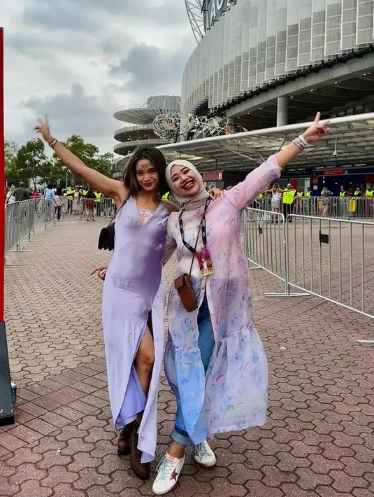 Acha Septriasa nonton konser Taylor Swift di Australia mengenakan slit dress ungu berkerah v neck. Dengan riasan wajah mengenakan manik-manik. [@septriasaacha]