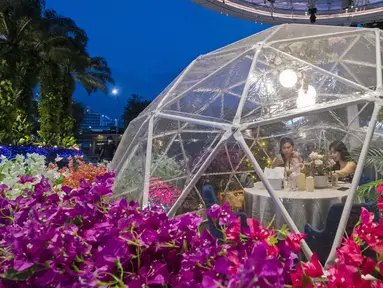 Orang-orang menyantap makanan dalam dining dome, instalasi tempat makan berbentuk kubah yang membantu mencegah penyebaran COVID-19, di Capitol Singapore Outdoor Plaza, Singapura, 21 Oktober 2020. (Xinhua/Then Chih Wey)