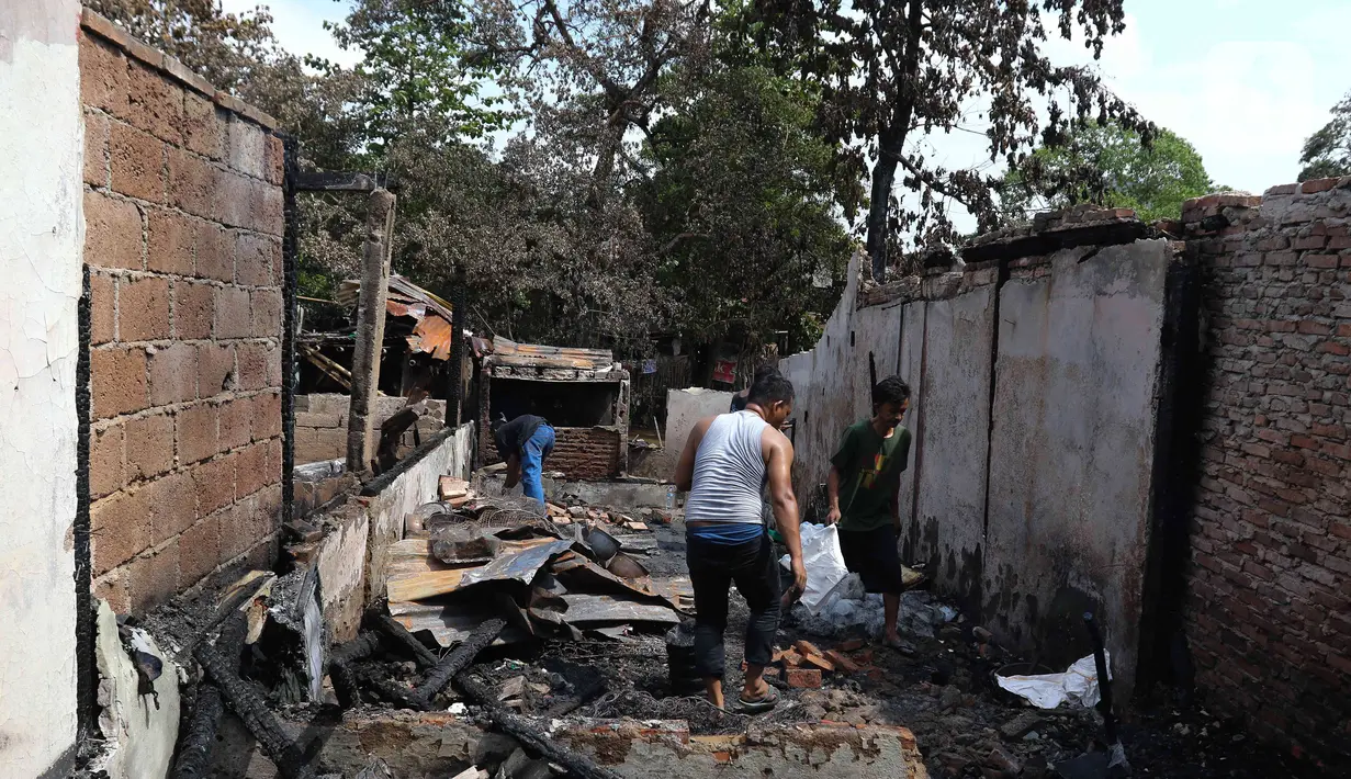 Warga mencari barang-barang miliknya pasca kebakaran pemukiman di kawasan Manggarai, Jakarta, Minggu (18/12/2022). Kebakaran tersebut menghanguskan sekitar 50 rumah semi permanen yang ada di bantaran sungai Ciliwung. (Liputan6.com/Herman Zakharia)